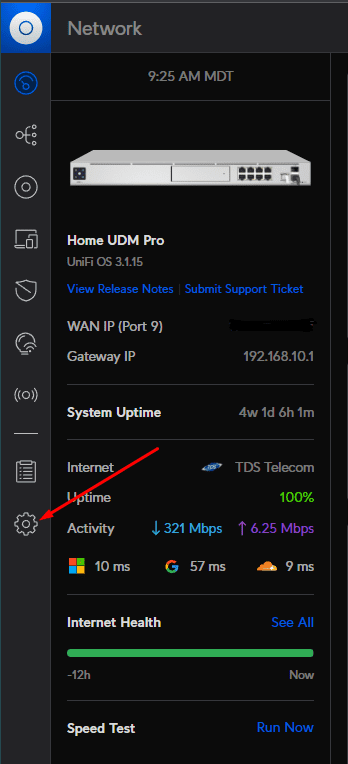 UniFi dashboard for a UDM Pro with an arrow pointing to the settings gear icon in the sidebar